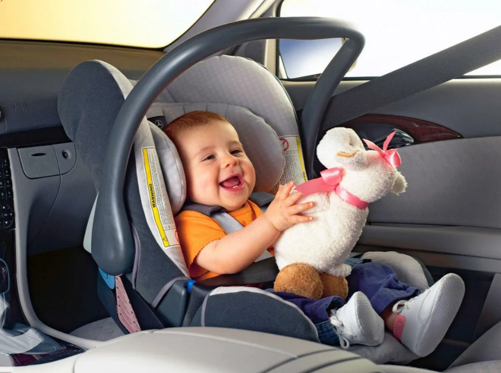Ребенок в удобной автолюльке с игрушкой